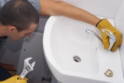 plumber installs a new faucet for a sink